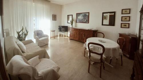un soggiorno con divano, tavolo e sedie di OLA apartment a Mantova