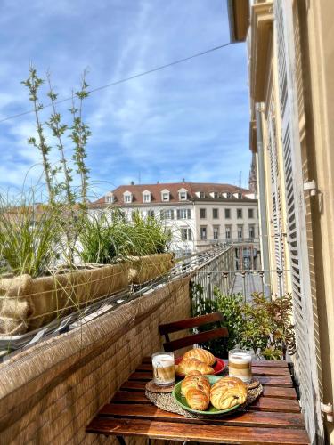 une table avec deux assiettes de nourriture sur un balcon dans l'établissement Aux Arcades Mulhouse Hyper Centre, à Mulhouse