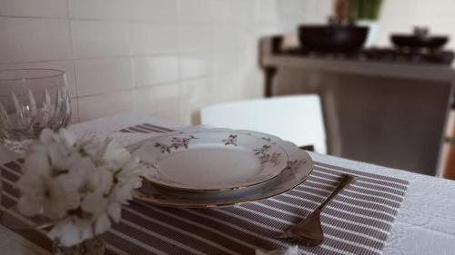un tavolo con piatto, forchetta e ciotola di fiori di OLA apartment a Mantova