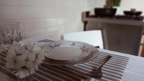 a table with a plate and a fork and a bowl of flowers at OLA apartment in Mantova