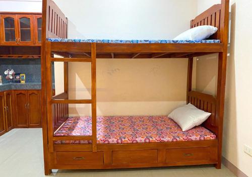 Litera de madera con almohada en Cozy Studio Apartment with Free Parking en Bayombong