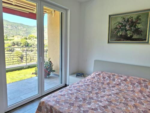 a bedroom with a bed and a sliding glass door at Dolce Far Niente in Alassio