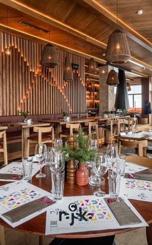 a restaurant with a table with glasses on it at Apartman Drvorez-direktno na ski stazi in Jahorina