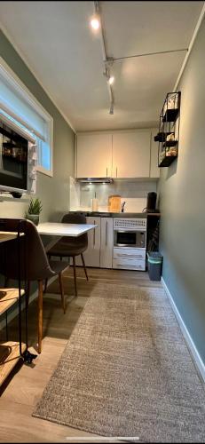 a kitchen with a table and a dining room at Strøken liten leilighet i Svolvær. in Svolvær