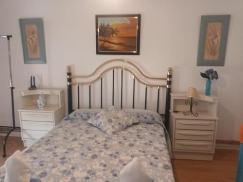 een slaapkamer met een bed en twee nachtkastjes bij Vista a la sierra in El Astillero