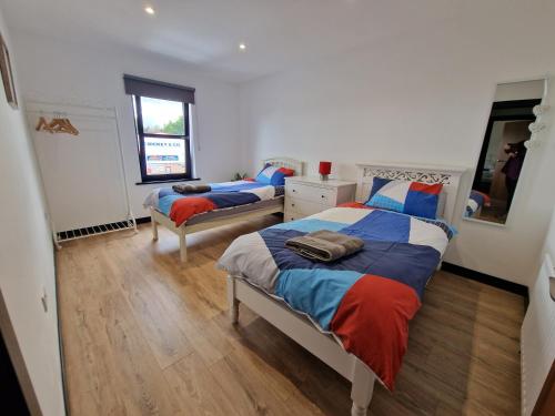 a bedroom with two beds and a mirror at Milltate House Apartments in Irvinestown