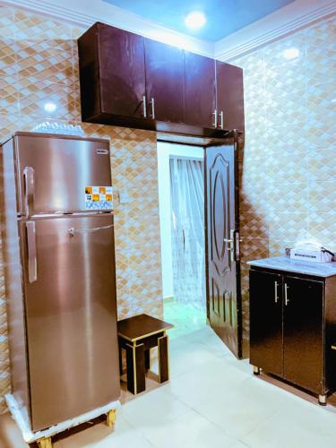 a kitchen with a stainless steel refrigerator in a room at Select Captivating Room with 1kingsized bed in Abuja