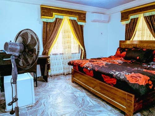 a bedroom with a bed and a fan in a room at Select Captivating Room with 1kingsized bed in Abuja