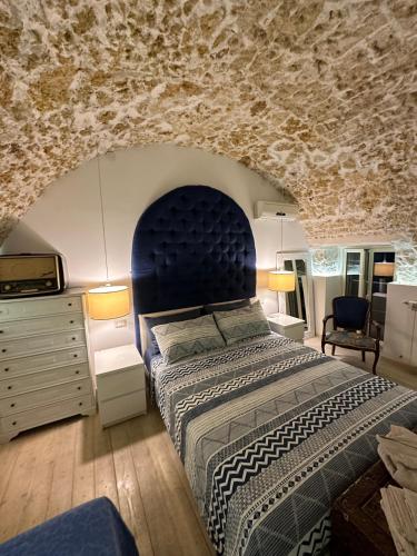 um quarto com uma cama grande e uma parede de pedra em Andive em Siracusa