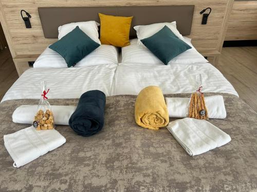 Una cama grande con mantas y toallas. en Dani Wellness Apartman, en Zalakaros