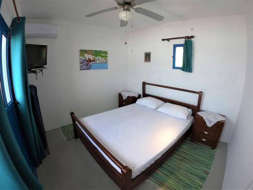 a bedroom with a bed and a flat screen tv at AGIAS PELAGIAS LITTLE BEACH HOUSE in Agia Pelagia Kythira