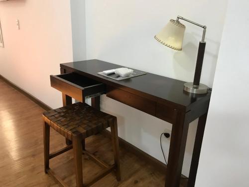 a black desk with a lamp and a stool at Depto Cívico in San Juan