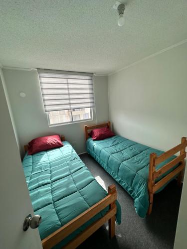 1 dormitorio con 2 camas y ventana en la florida aeropuerto, en La Serena
