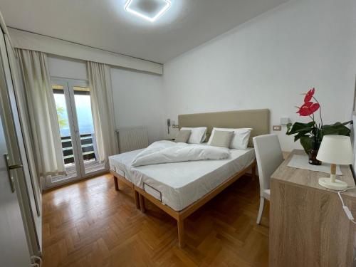 a white bedroom with a bed and a table at Naturhotel Wieserhof in Longostagno