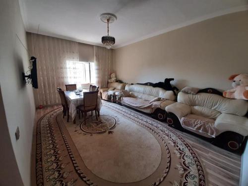 a living room with two couches and a table and a dining room at Nabran Suite in Aşağıoba