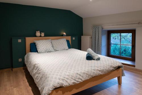 Lierneux的住宿－Le Temps d'une Fugue，一间卧室设有一张大床和绿色的墙壁
