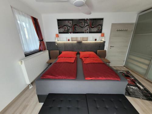 een slaapkamer met 2 bedden en rode kussens bij Penthouse-Apartment AM KORNFELD in Lünen