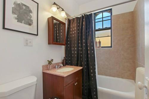 ein Bad mit einem Waschbecken und einem Duschvorhang in der Unterkunft Enchanting 1-Bedroom Lakeview Apartment - Belmont F6 in Chicago