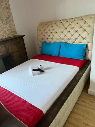 Una cama con almohadas azules y un libro. en Joyous lodges en Ciudad del Cabo