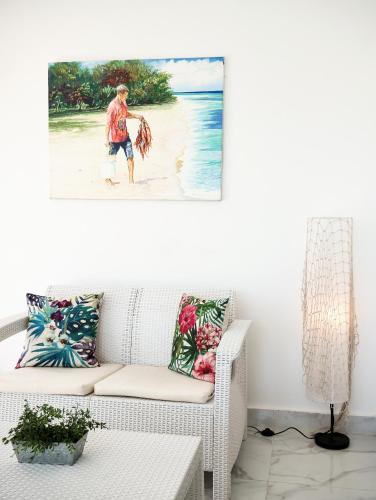a living room with a couch and a picture of a man on the beach at Coconut Paradise Beach Hotel in Pajarito