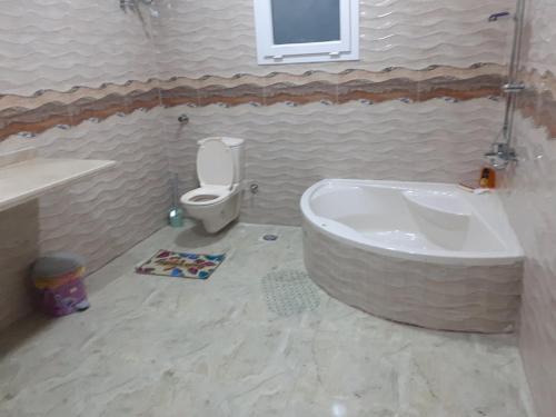 a bathroom with a tub and a toilet at Sun, Sea & Comfort in Hurghada