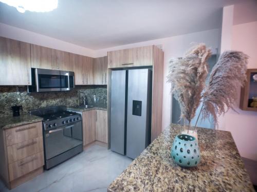 a kitchen with wooden cabinets and a vase on a counter at Coconut Paradise Beach Hotel in Pajarito