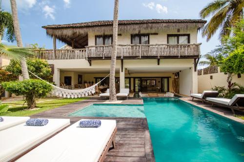 a villa with a swimming pool and a house at Casa Elea in Jericoacoara