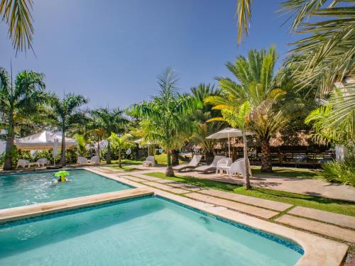 a swimming pool in a resort with palm trees at Coconut Paradise Beach Hotel in Pajarito
