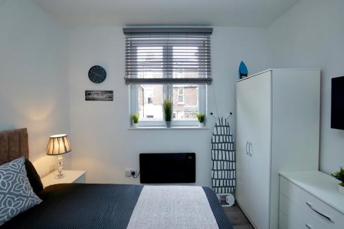 1 dormitorio con cama y ventana en Luxury Flats in Southsea Portsmouth, en Portsmouth