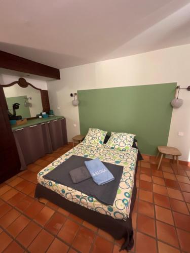a bedroom with a bed with a green headboard at Ananas Premium in La Trinité