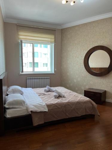 1 dormitorio con 1 cama con 2 toallas en "3-Bedroom Charming Apartment in Central Almaty", en Almaty