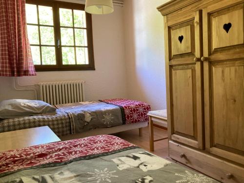 um pequeno quarto com 2 camas e um armário em Les Pâturages em La Bresse
