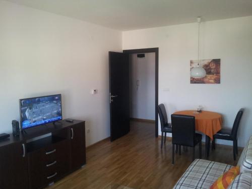 een woonkamer met een eettafel en een televisie bij Sweet Apartment in Belgrado