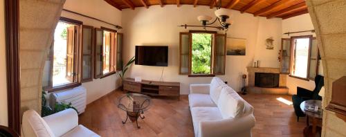 a living room with white furniture and a tv at Suite del Capitano in Rhodes Town