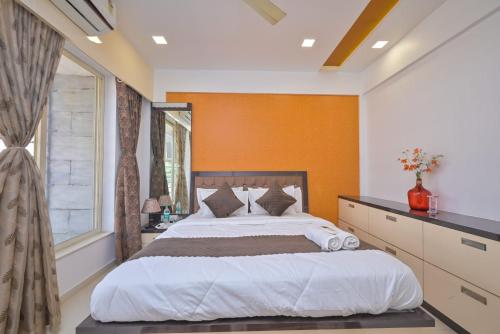 a bedroom with a large bed and a window at shubh villa 4bhk in Lonavala