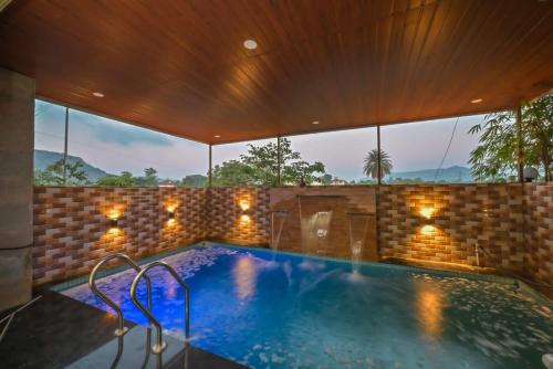 a swimming pool in a house with a large window at shubh villa 4bhk in Lonavala