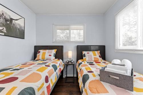 2 camas en una habitación con paredes y ventanas blancas en The Bamboo House! Dog-Friendly Home n RVA Sleeps 8, en Richmond