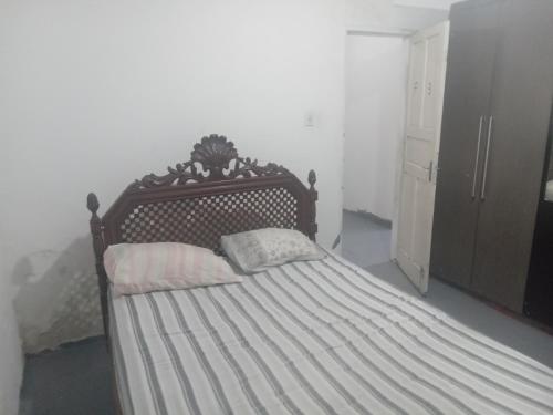 um quarto com uma cama e uma cabeceira em madeira em Hostel Leonardo Quarto com cama de casal em Vitória