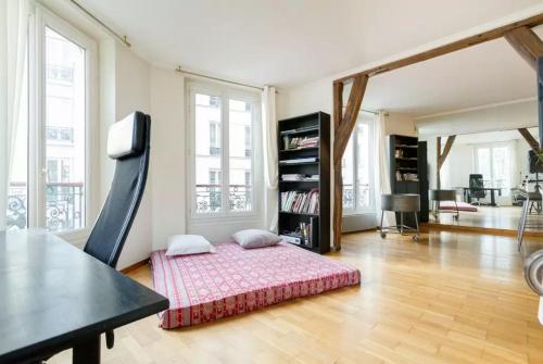 uma sala de estar com uma cama no meio do quarto em Appartement Paris Centre Vavin em Paris
