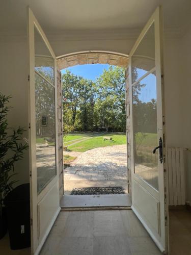 an open door with a view of a yard at Charming Barbizon Villa in Barbizon