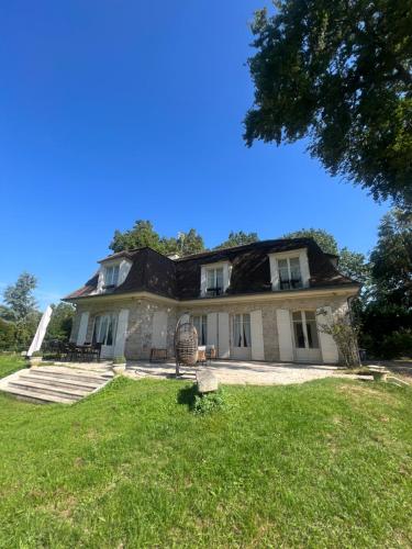 a large house on a grassy field with a tree at Charming Barbizon Villa in Barbizon