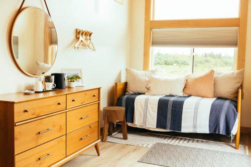 a bedroom with a bed with a mirror and a dresser at The Lodge at 58* North in King Salmon