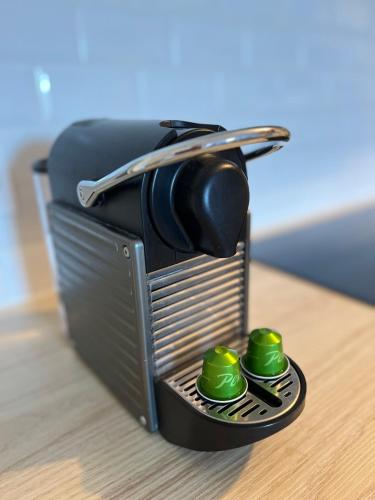 une petite boîte métallique avec deux sphères vertes dans celle-ci, dans l'établissement Sweet Abreuvoir, à Saint-Germain-en-Laye