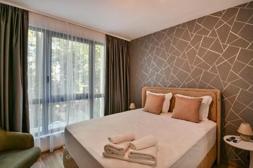 1 dormitorio con 1 cama con toallas en The Shangri-LA flat en Saints Constantine and Helena