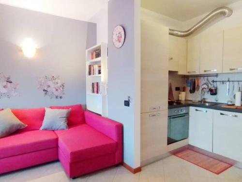 sala de estar con sofá rosa en la cocina en il Sole di Busto APT, en Busto Arsizio