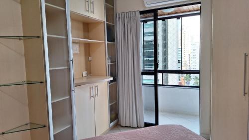 1 dormitorio con ventana grande y armario blanco en Apartamento na Praia Central de BC, ideal para você e sua família, en Balneário Camboriú