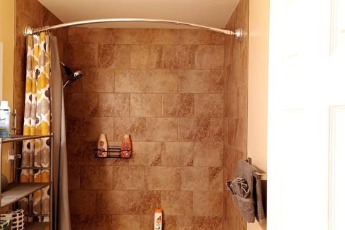 a bathroom with a shower with two shoes on a shelf at Comforts of Home in Gautier