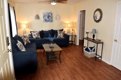 a living room with a blue couch and a table at Comforts of Home in Gautier