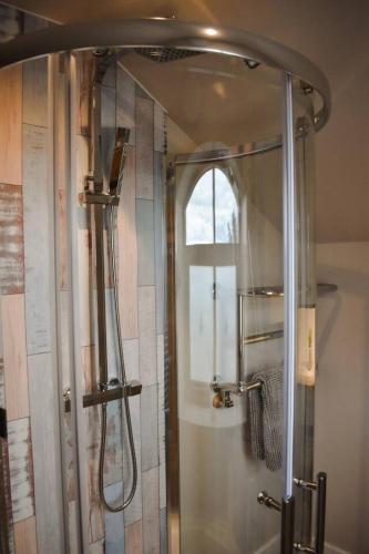 a shower in a bathroom with a window at Cedar Cottage in Eckington