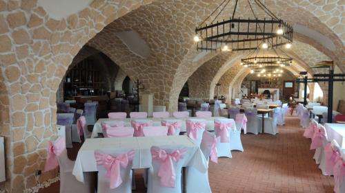 une salle de banquet avec des tables blanches et des archets roses dans l'établissement Rittergut Dröschkau, à Dröschkau